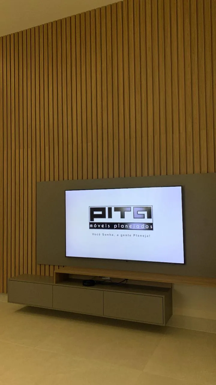 Painel de TV planejado pela Pita, com a logo da empresa exibida na tela